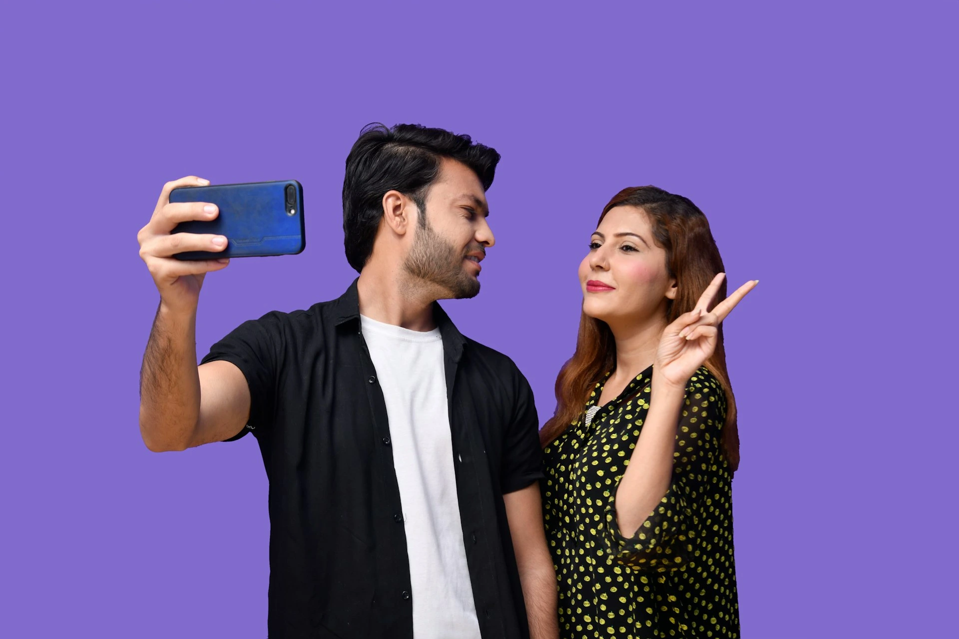 a man and woman holding a phone